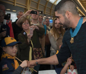 Medal of Honor Recipient Florent Groberg greets a young Scout.