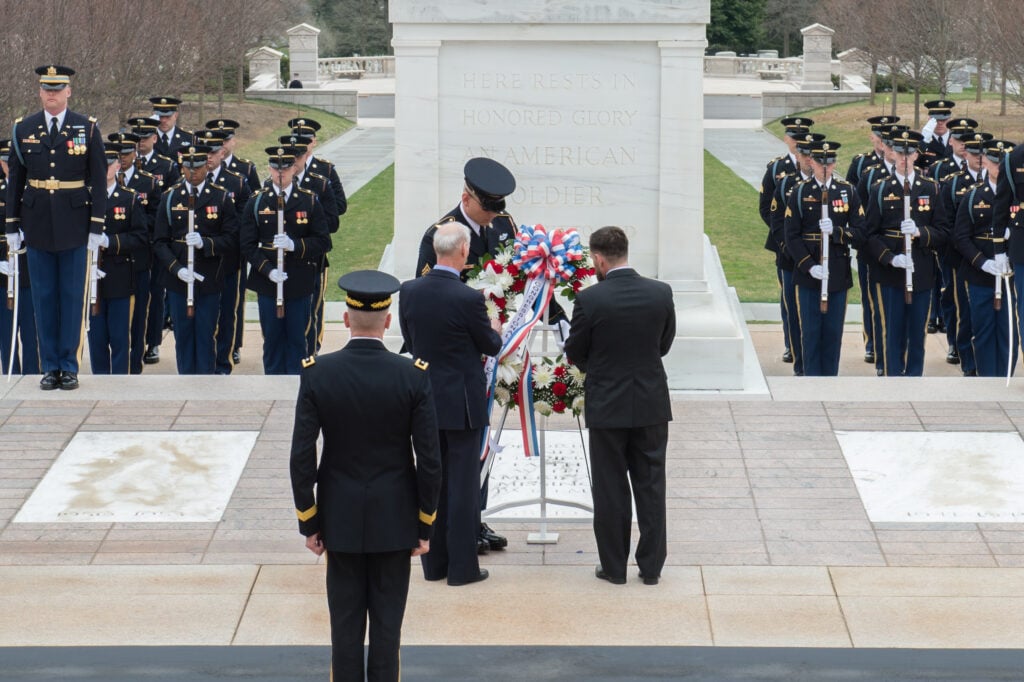 Men standing at the tomb of the unknown soldier for a wreath laying ceremony